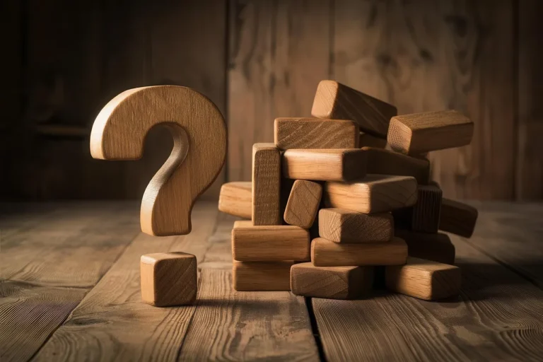 Een groot houten vraagteken staat naast een slordige stapel houten blokken op een rustieke houten ondergrond.